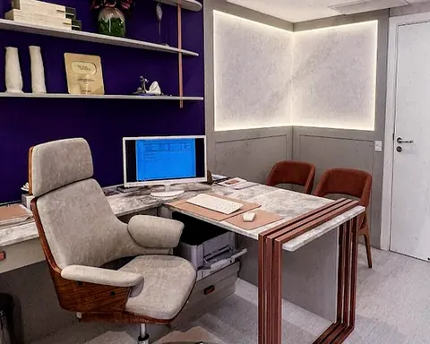 Consultório da Dra. Cínthia, com mesa, poltronas e prateleiras roxas